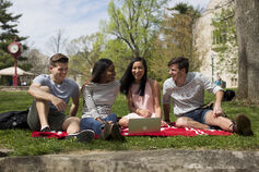 A group of students sits together on campus